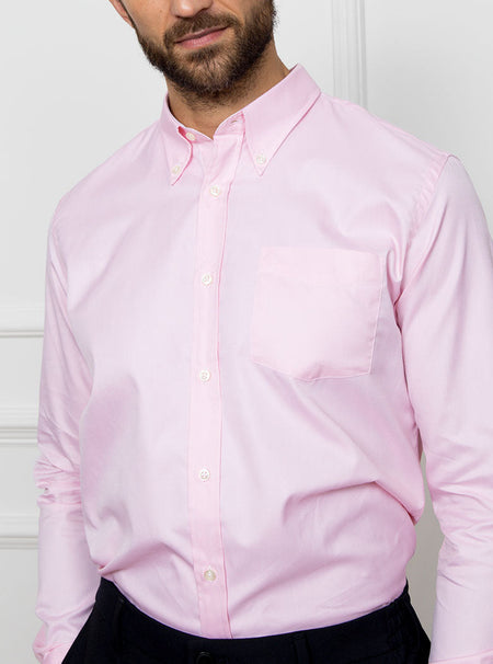Man wearing a pale pink long sleeved shirt with a button down collar made with 100% Royal Oxford Cotton.